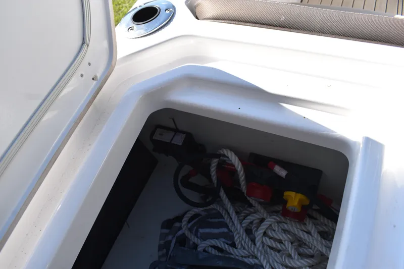 Slide: The Image of 2023 Yamaha Boats 252 FSH Sport electrical wiring and battery switches in compartment. - 49
