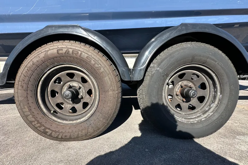 Slide: The Image of Trailer wheels of a 2023 Yamaha Boats 252 FSH Sport, parked on asphalt. - 57