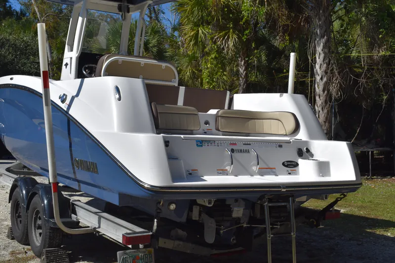 Slide: The Image of 2023 Yamaha Boats 252 FSH Sport on trailer under bright sun. - 6