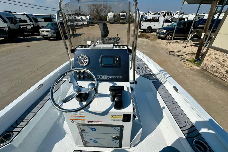 Slide: The Image of 2026 Express H20B boat interior with steering wheel and control panel, parked near RVs. - 16