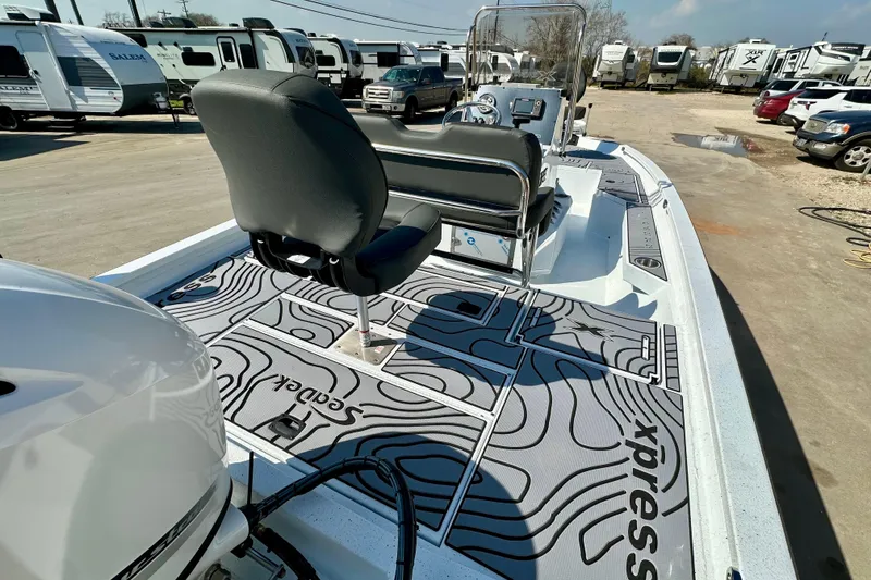 Slide: The Image of 2026 Express H20B boat with custom deck design, parked among RVs. - 8