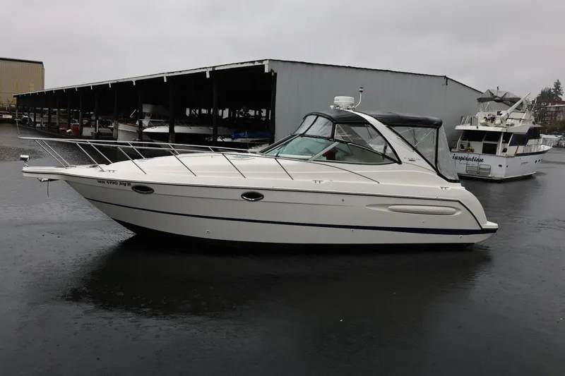 The Image of 2005 Maxum 3300 SE boat docked in a marina on a cloudy day. - 0