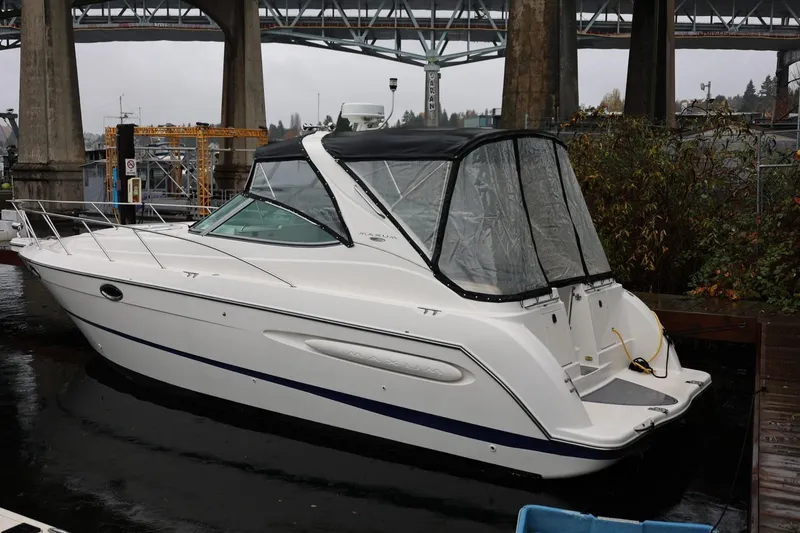 Slide: The Image of 2005 Maxum 3300 SE boat docked under a bridge on a cloudy day. - 12