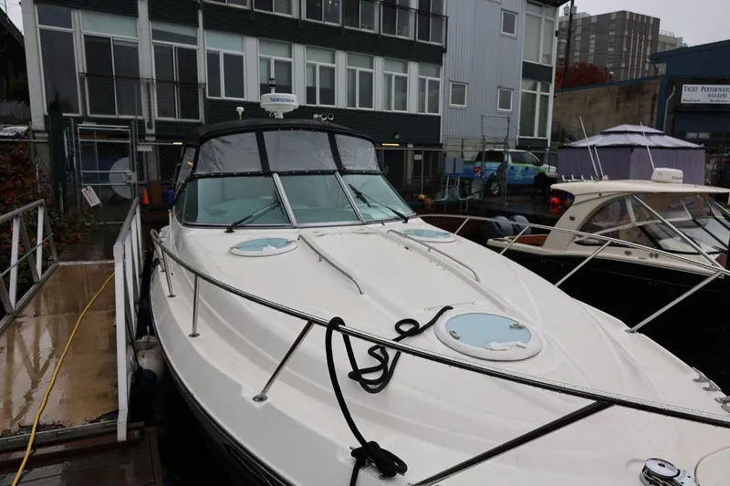 Slide: The Image of 2005 Maxum 3300 SE boat docked near modern buildings on a rainy day. - 16