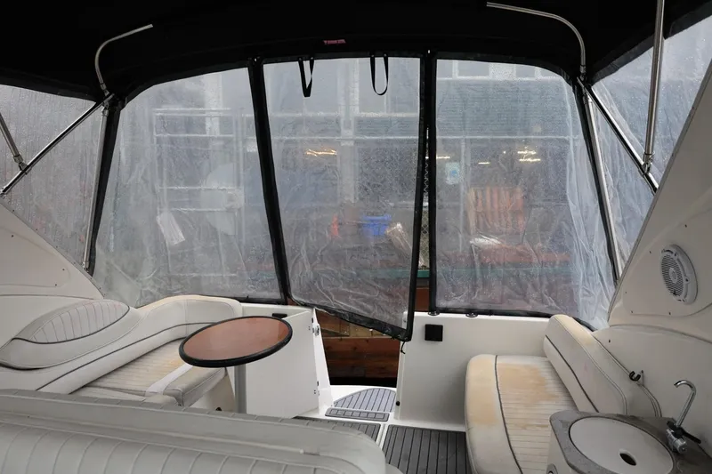 Slide: The Image of 2005 Maxum 3300 SE boat interior with seating and table under canopy. - 19