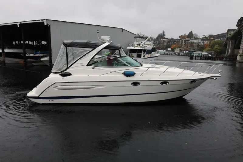 Slide: The Image of 2005 Maxum 3300 SE boat docked on a rainy day, side view. - 2