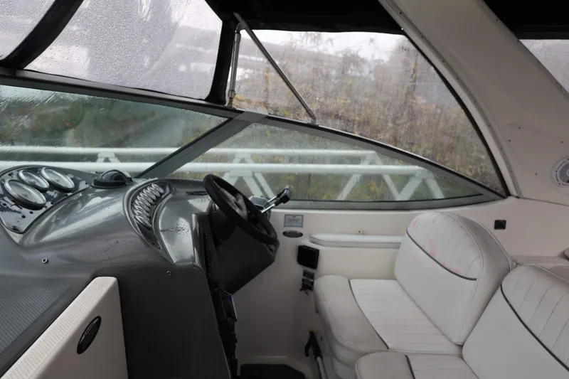 Slide: The Image of 2005 Maxum 3300 SE boat interior with steering wheel and white seating. - 22