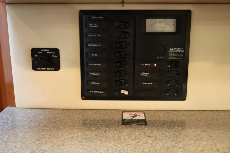 Slide: The Image of Electrical control panel on a 2005 Maxum 3300 SE boat, featuring various switches and a voltmeter. - 27