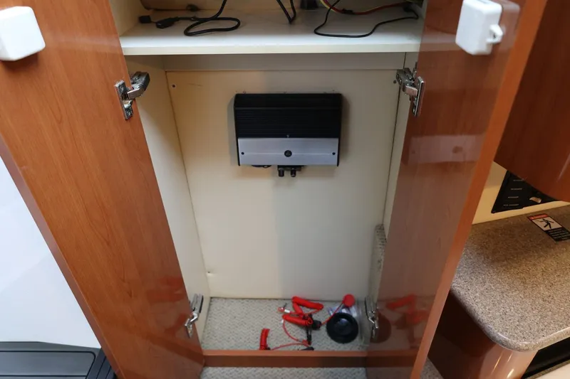 Slide: The Image of Open cabinet in 2005 Maxum 3300 SE boat with electronic device and cables inside. - 29