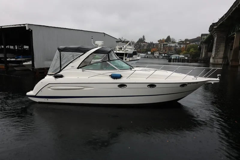 Slide: The Image of 2005 Maxum 3300 SE boat docked on a rainy day near a bridge. - 3