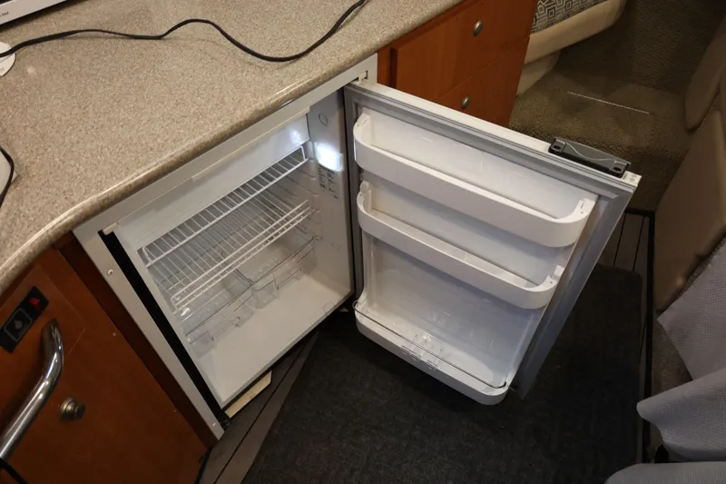 Slide: The Image of Open refrigerator in 2005 Maxum 3300 SE boat interior, showcasing storage space. - 31