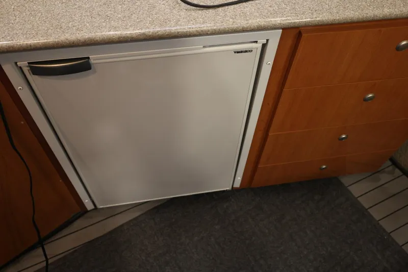 Slide: The Image of 2005 Maxum 3300 SE boat interior with fridge and wooden cabinetry. - 32