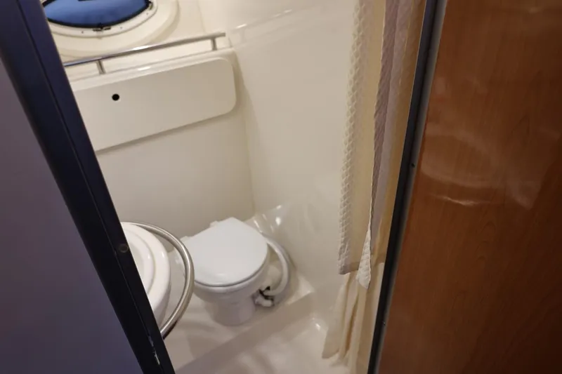 Slide: The Image of 2005 Maxum 3300 SE boat bathroom with toilet and shower curtain. - 35