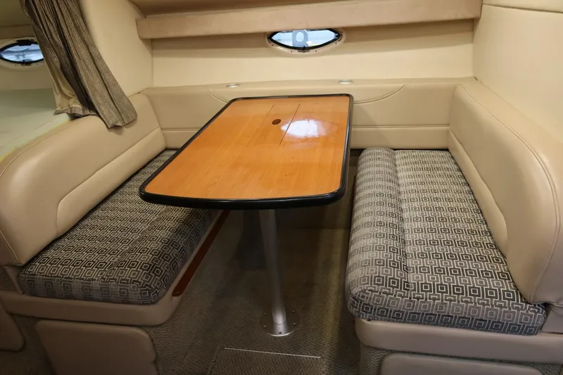 Slide: The Image of 2005 Maxum 3300 SE interior with beige seating and wooden table. - 37