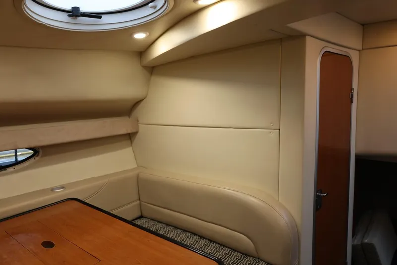 Slide: The Image of Interior of 2005 Maxum 3300 SE boat with beige seating and wooden table. - 38