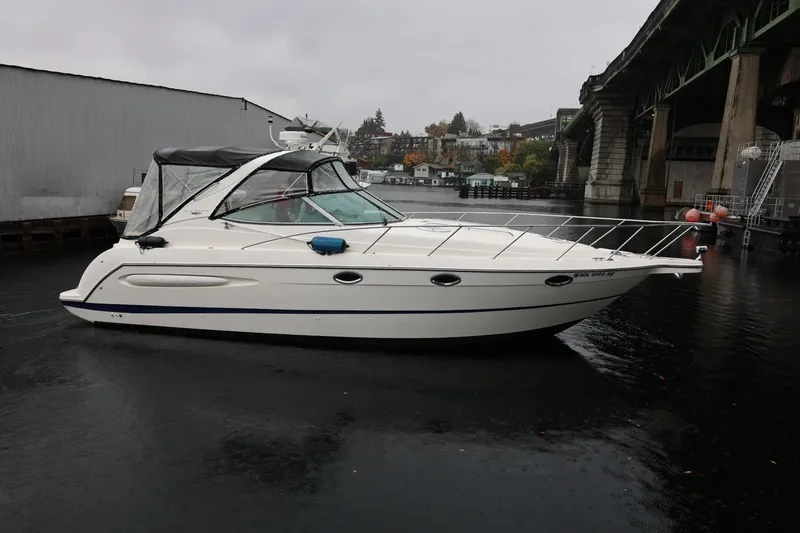 Slide: The Image of 2005 Maxum 3300 SE boat docked under a bridge on a cloudy day. - 4