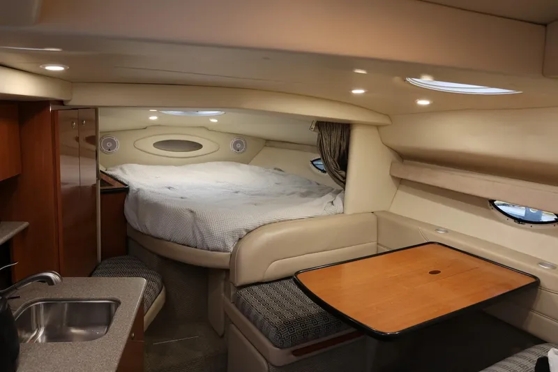 Slide: The Image of 2005 Maxum 3300 SE cabin interior with bed, table, and kitchenette. - 41