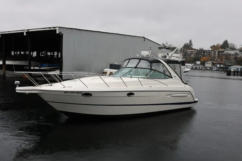 Slide: The Image of 2005 Maxum 3300 SE boat docked on a rainy day near a marina. - 8