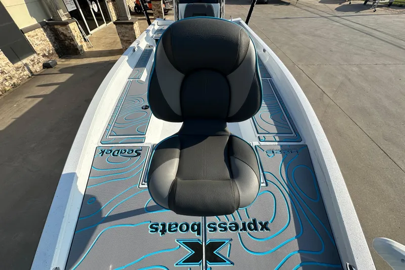 Slide: The Image of 2026 Express H22B boat with stylish seating and SeaDek flooring in a showroom. - 14