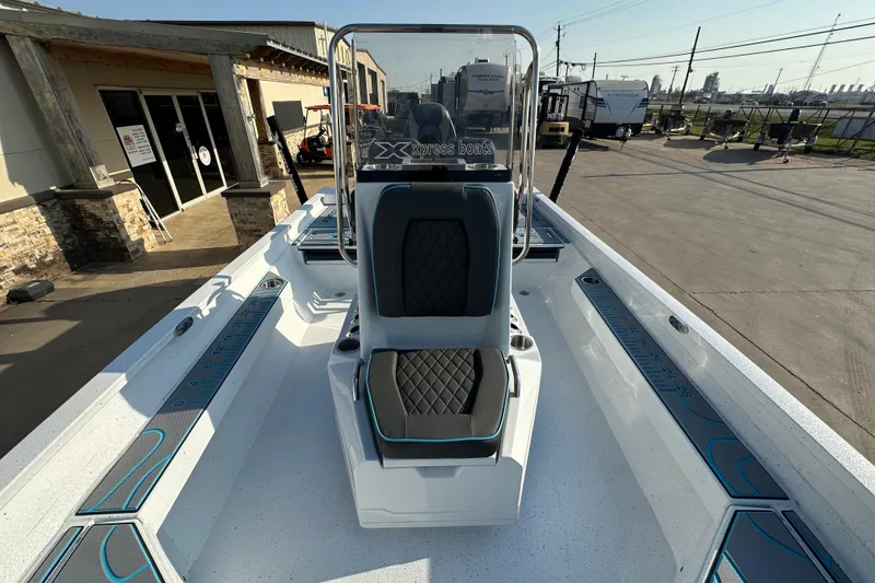 Slide: The Image of 2026 Express H22B boat interior with modern seating and dashboard, parked outdoors. - 15