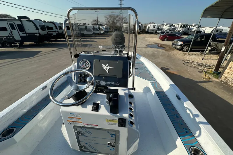 Slide: The Image of 2026 Express H22B boat dashboard with steering wheel and control panel, parked near RVs. - 16