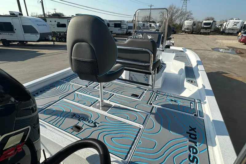 Slide: The Image of 2026 Express H22B boat interior with seating and storage, parked near RVs. - 8