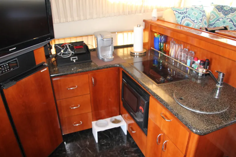 Slide: The Image of 2004 Carver 360 Sport Sedan kitchen with modern appliances and wooden cabinetry. - 14