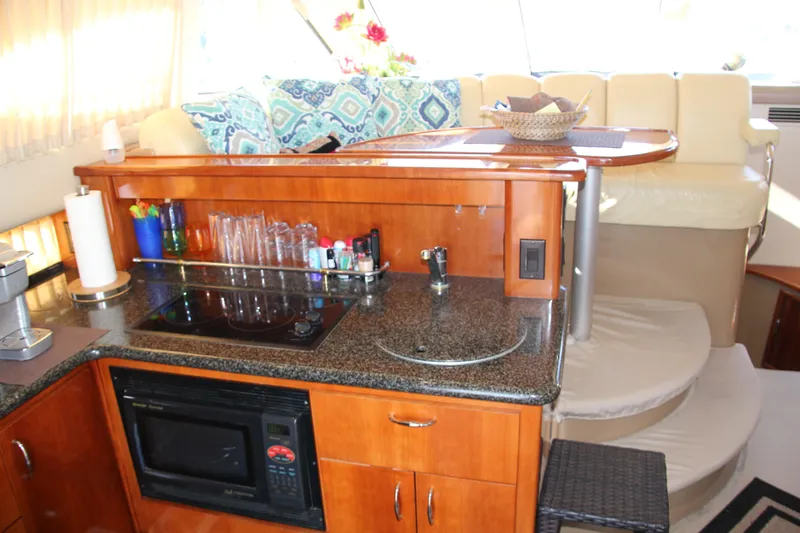 Slide: The Image of 2004 Carver 360 Sport Sedan interior with kitchen, microwave, and seating area. - 16