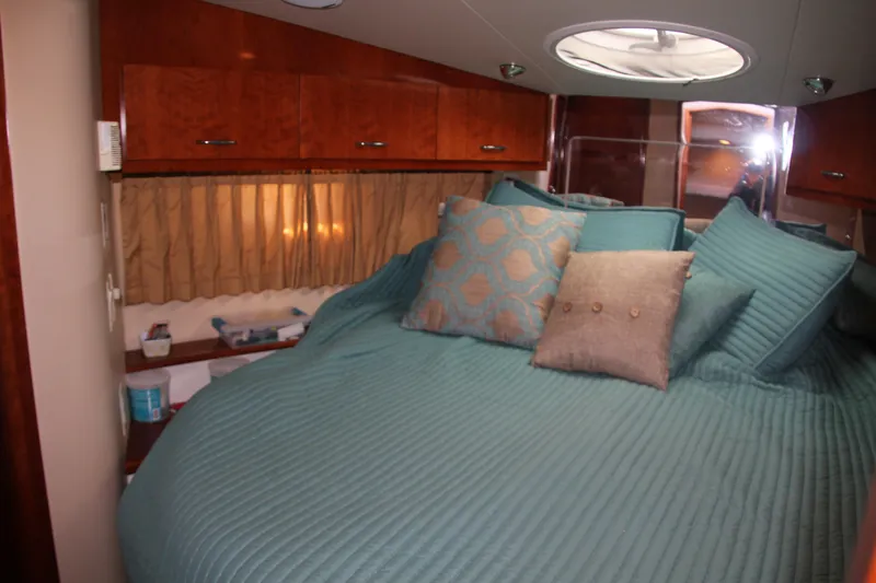 Slide: The Image of Luxurious bedroom interior of 2004 Carver 360 Sport Sedan with teal bedding and wooden cabinets. - 17
