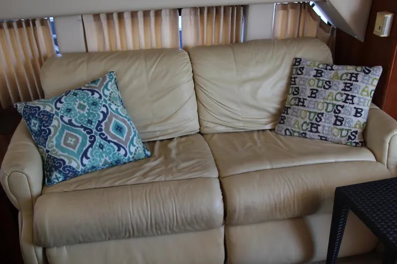Slide: The Image of Beige leather sofa with patterned cushions inside a 2004 Carver 360 Sport Sedan. - 18