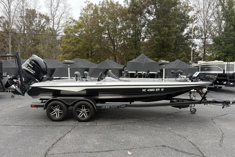 Slide: The Image of 2021 Skeeter ZXR20 boat on trailer, parked outdoors with trees in the background. - 7