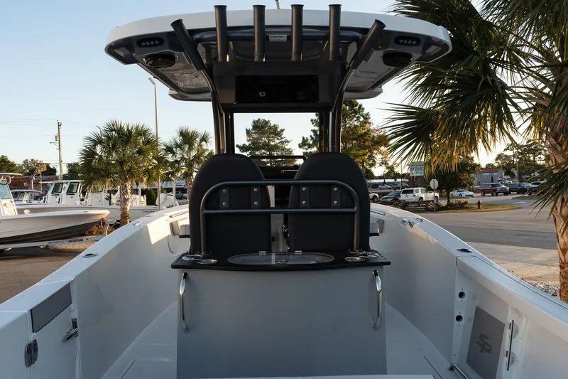 Slide: The Image of 2026 Sea Pro 262 Offshore boat interior with seating, rod holders, and palm trees in the background. - 7