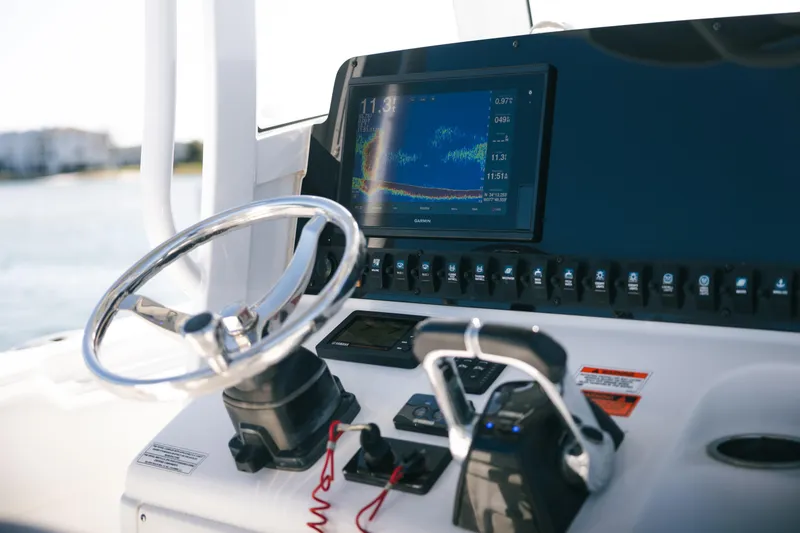 Slide: The Image of 2019 Sea Hunt Gamefish 27 Coffin Box dashboard with steering wheel and navigation display. - 10