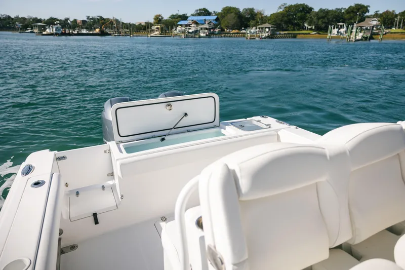 Slide: The Image of 2019 Sea Hunt Gamefish 27 Coffin Box boat on calm water, featuring comfortable seating. - 17