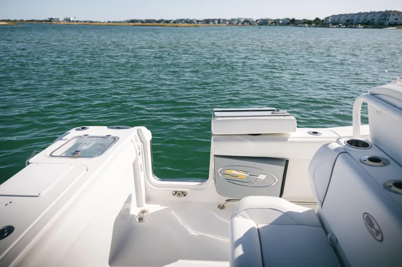 Slide: The Image of 2019 Sea Hunt Gamefish 27 Coffin Box boat on calm water, featuring sleek seating and storage. - 18