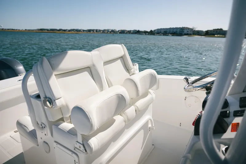 Slide: The Image of 2019 Sea Hunt Gamefish 27 Coffin Box boat interior with white seating and steering wheel. - 19
