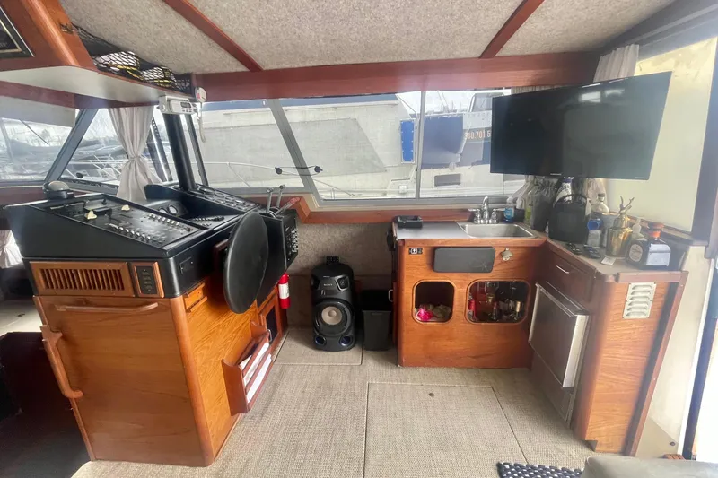 Slide: The Image of 1983 Bayliner 3888 MY Sedan interior with helm, sink, and entertainment area. - 12