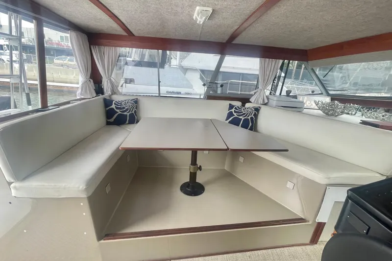 Slide: The Image of 1983 Bayliner 3888 MY Sedan interior with seating area and table, featuring nautical decor. - 14