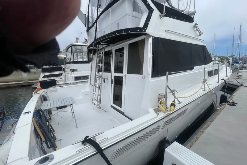 Slide: The Image of 1983 Bayliner 3888 MY Sedan docked at marina, featuring spacious deck and modern design. - 2