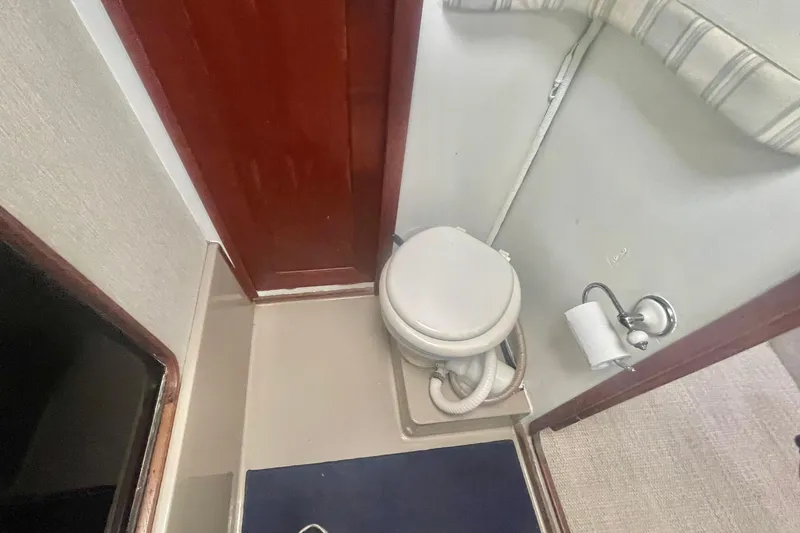 Slide: The Image of 1983 Bayliner 3888 MY Sedan bathroom with toilet and wooden door. - 20