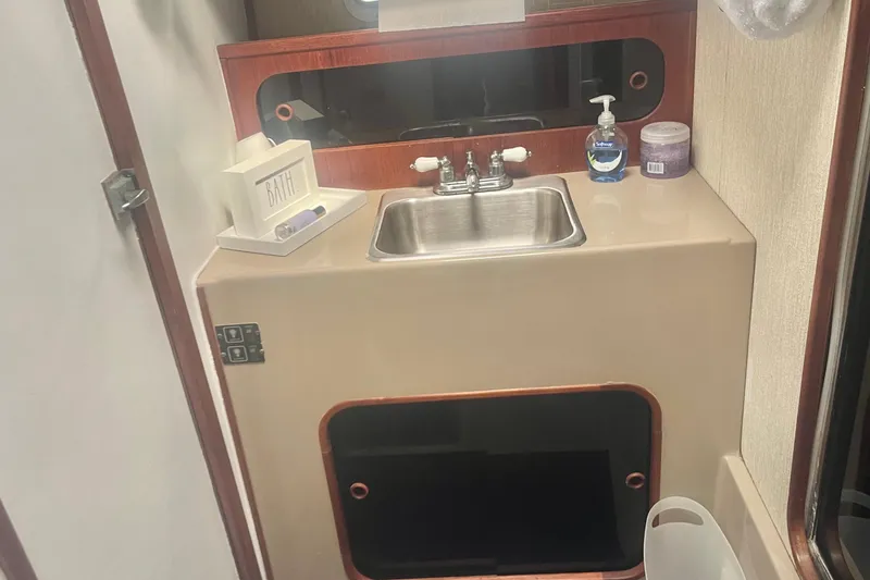 Slide: The Image of 1983 Bayliner 3888 MY Sedan bathroom with sink, mirror, and toiletries. - 21