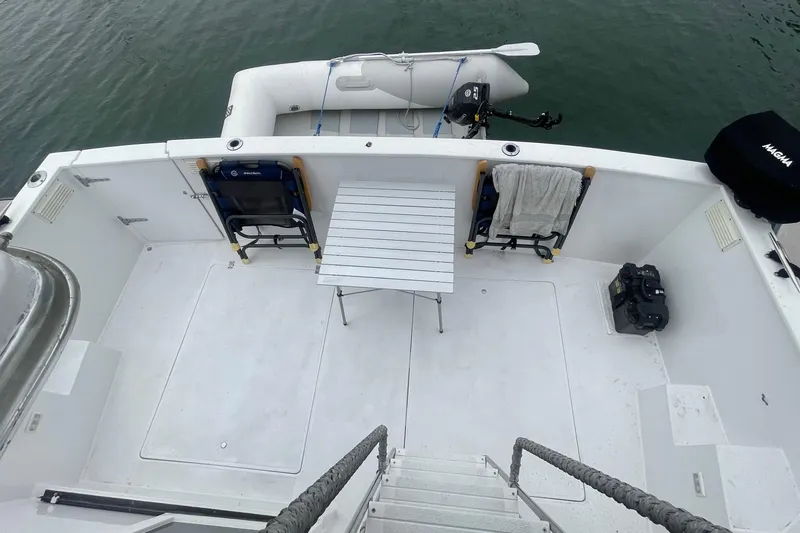 Slide: The Image of 1983 Bayliner 3888 MY Sedan deck with chairs, table, and inflatable boat. - 4