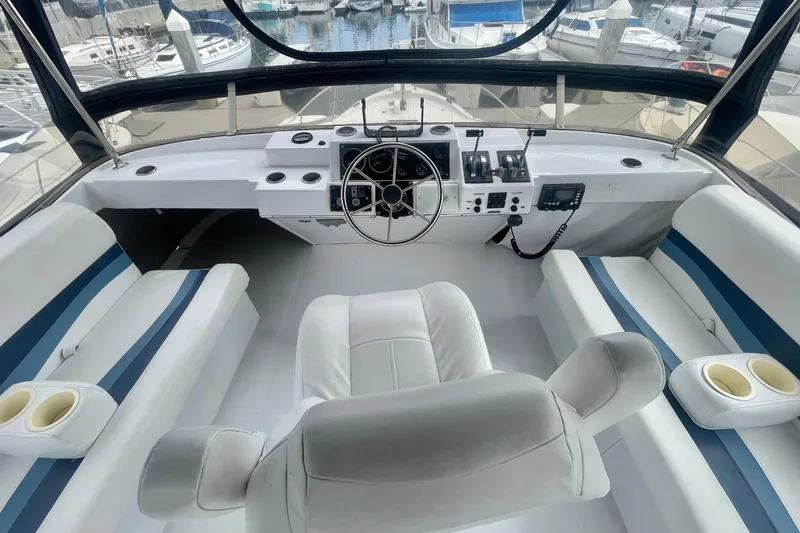 Slide: The Image of Cockpit of 1983 Bayliner 3888 MY Sedan with white seating and steering wheel. - 6