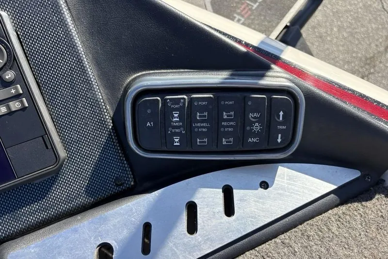 Slide: The Image of Control panel of a 2018 Triton 20 TrX Patriot boat with various switches. - 11