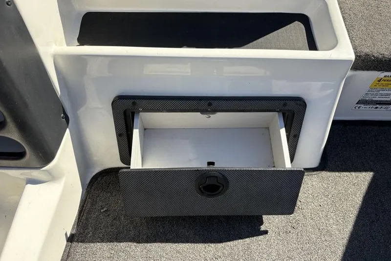 Slide: The Image of Open storage compartment on a 2018 Triton 20 TrX Patriot boat. - 24