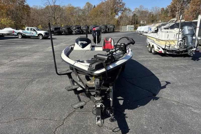Slide: The Image of 2018 Triton 20 TrX Patriot boat on trailer in parking lot, surrounded by trees. - 3