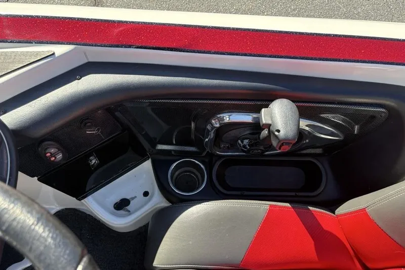 Slide: The Image of Interior of a 2018 Triton 20 TrX Patriot boat, featuring controls and red seating. - 31