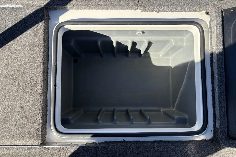 Slide: The Image of 2018 Triton 20 TrX Patriot storage compartment, open and empty, with gray interior. - 33