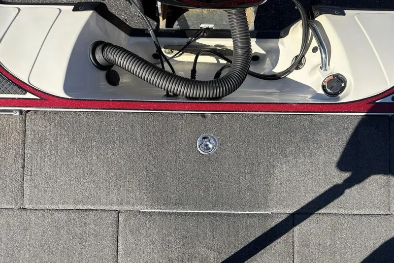 Slide: The Image of 2018 Triton 20 TrX Patriot boat deck with storage compartment and control panel. - 37