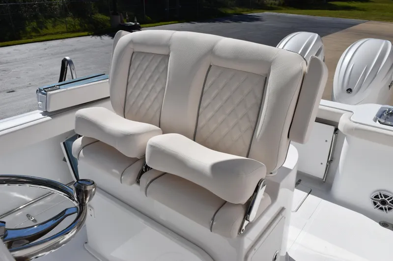 Slide: The Image of 2026 Sea Hunt Gamefish 25 boat with luxurious white seating and dual outboard engines. - 11